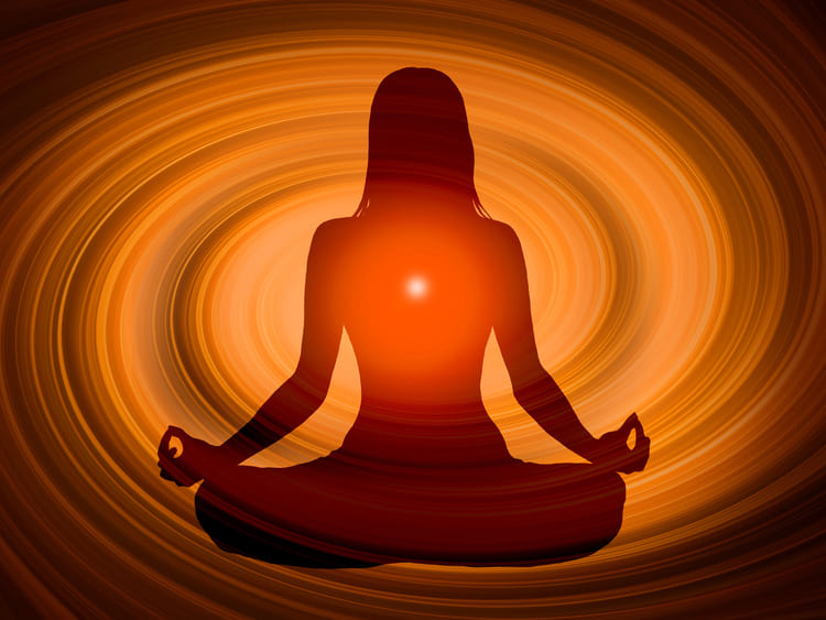 Silhouette einer meditierenden Person in Lotus-Haltung, mit einem leuchtenden Herzchakra vor einem warmen, orangefarbenen Hintergrund, der Energie und spirituelle Heilung symbolisiert. Kramische Muster erkennen